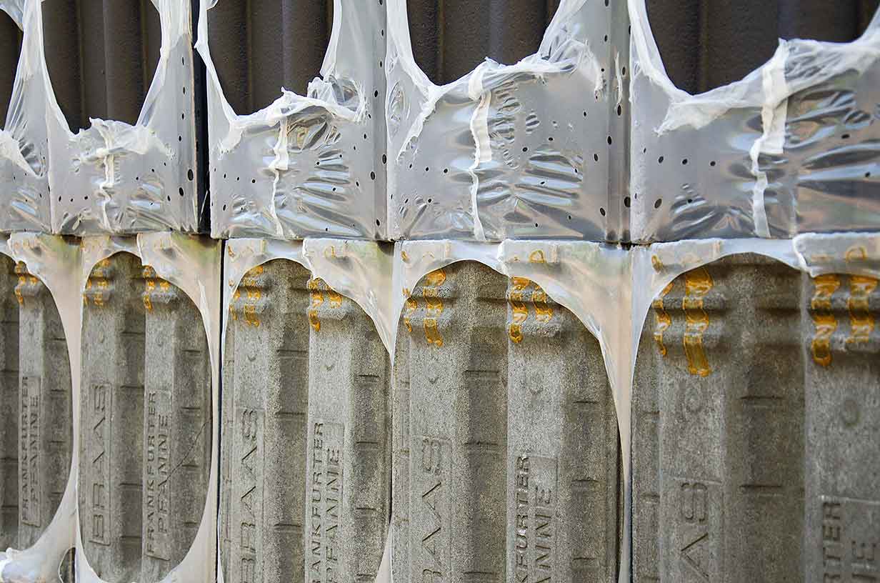 Mehrere aufeinander gestapelte Steinplatten mit teilweise durchsichtiger Schutzfolie bedeckt.