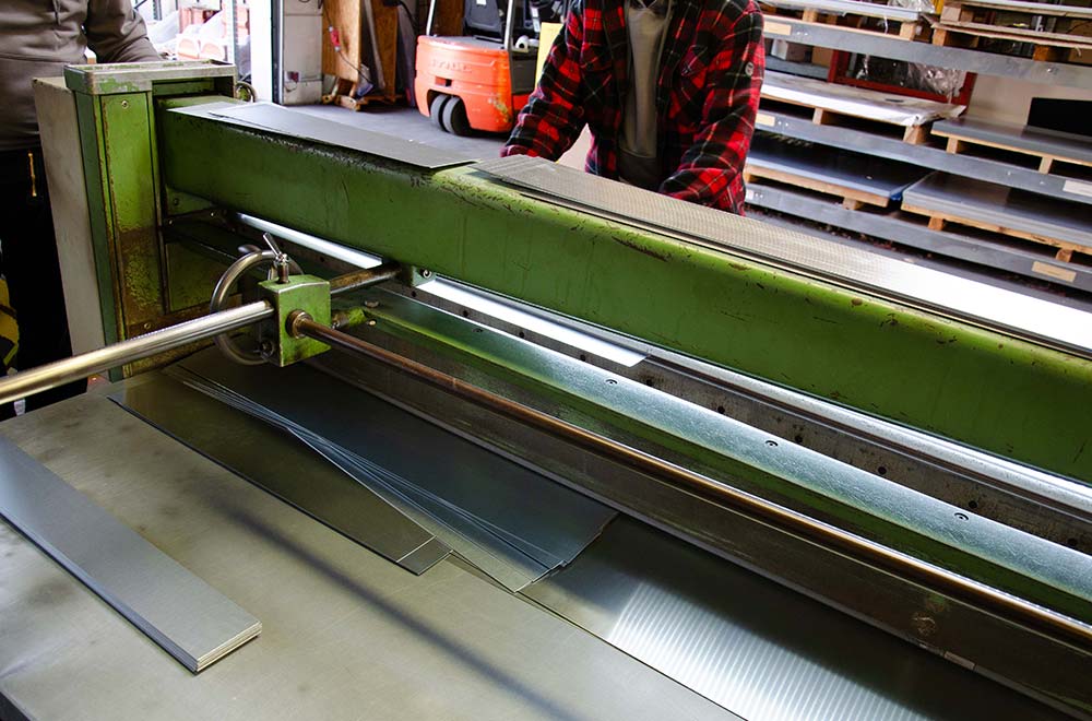 Metallverarbeitungsmaschine schneidet dünne Metallbleche in Fabrikumgebung.