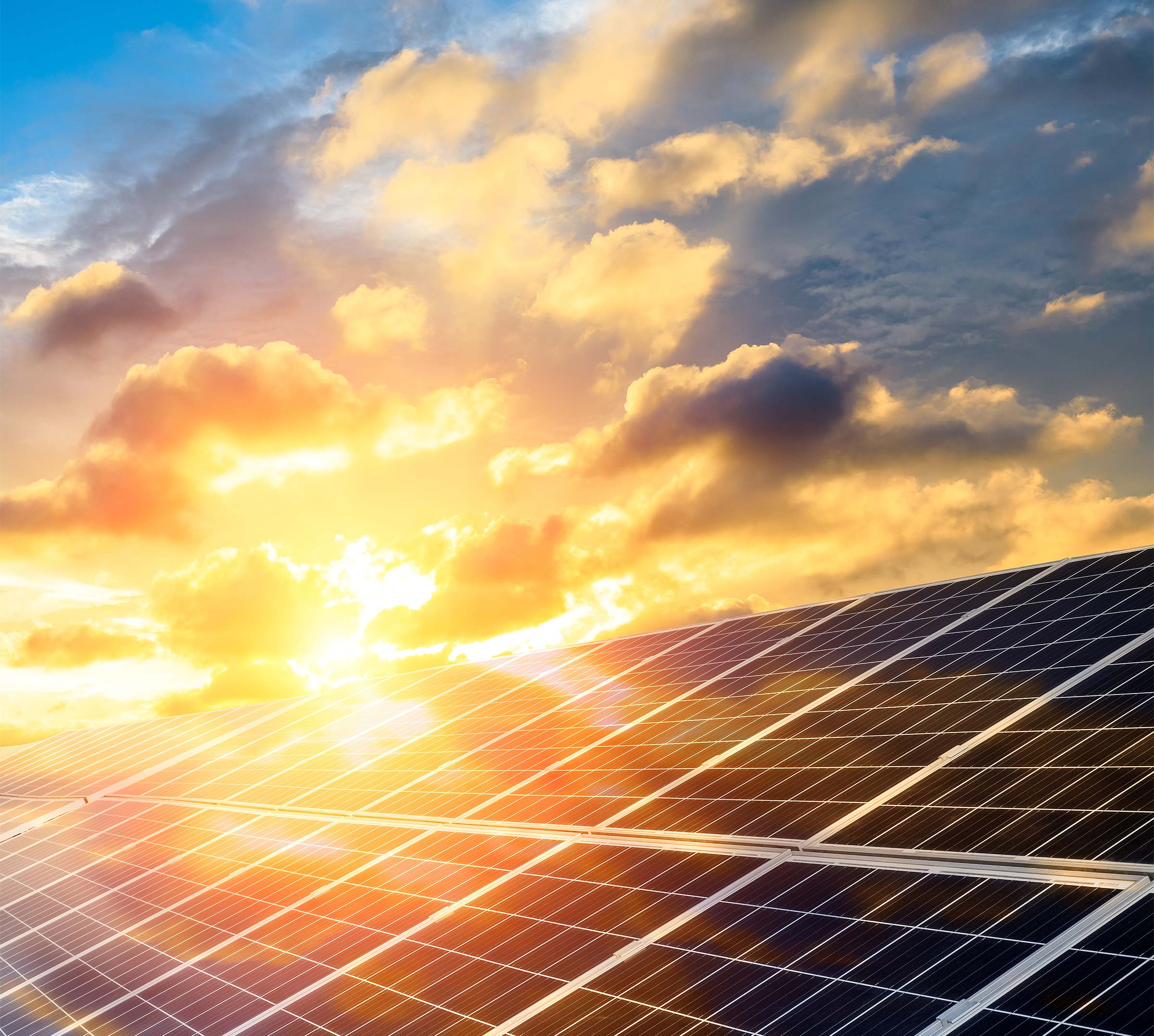 Solarmodule reflektieren Sonnenlicht bei Sonnenuntergang mit bewölktem Himmel.